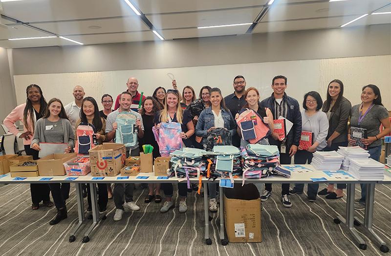 Employees putting together back-to-school backpacks for students.